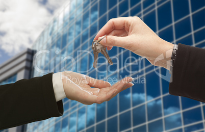 Female Handing Over the Keys in Front of Corporate Building