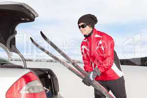 Woman with car during unloading of cross-country skis