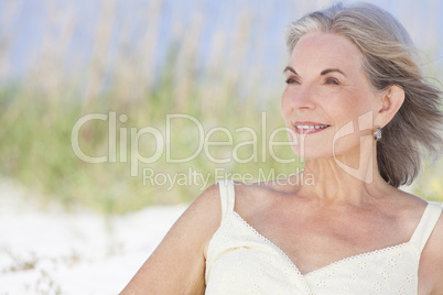 Attractive Senior Woman Sitting At Beach