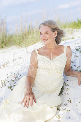 Attractive Senior Woman Sitting At Beach