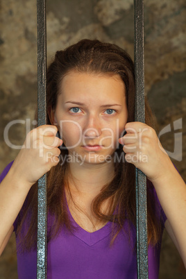 Young woman behind the bars