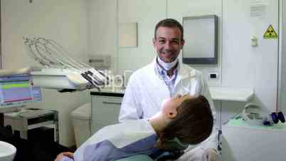 Portrait of happy caucasian dentist smiling at camera with client