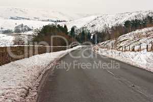 Empty road through snow covered Yorkshire moors