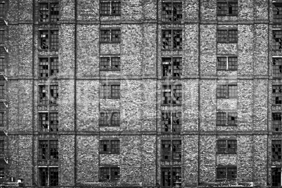 Broken windows in huge derelict warehouse