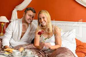 Smiling couple bed breakfast celebrating Valentine's