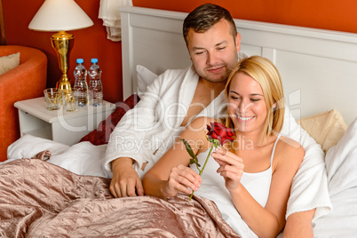 Loving couple celebrating romantic anniversary rose bed