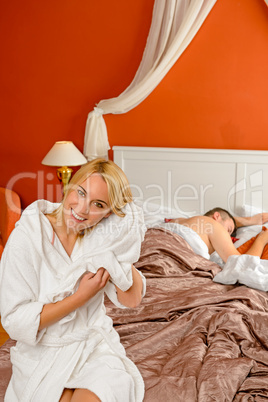 Smiling woman preparing drying hair boyfriend sleeping