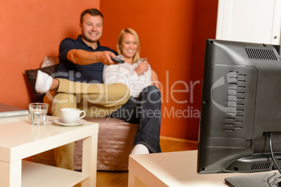 Happy couple watching tv evening changing channels