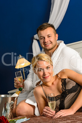 Intimate affair bed young couple drinking champagne