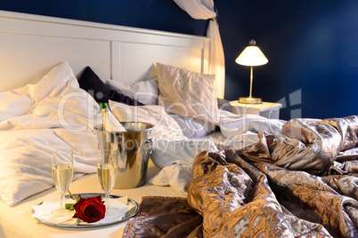 Romantic bedroom rumpled covers hotel champagne bucket