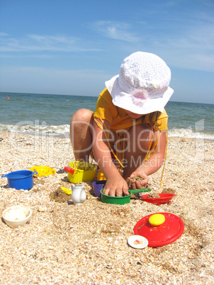 little girl plays at the sea