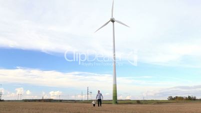 Father and son walking near the wind turbine.