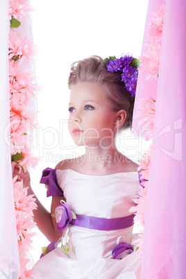 Pretty little child on swing in pink flowers