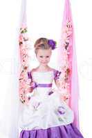 Beautiful little girl on floral swing
