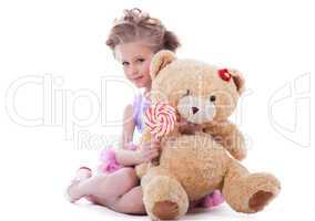 Little girl with lollipop and soft toy