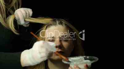 Hairdresser bleaching woman hair