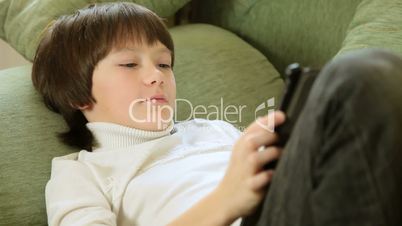 Child Using a Touch Screen Tablet PC At Home
