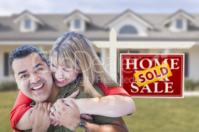 Mixed Race Couple in Front of Sold Real Estate Sign and House