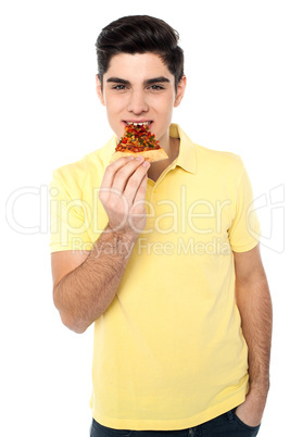 Happy young casual boy eating pizza