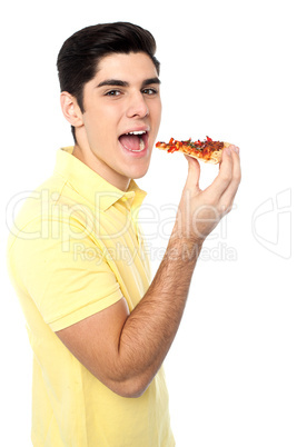 Young guy with a slice of pizza in hand