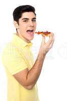 Young guy with a slice of pizza in hand