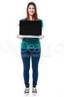 Casual girl presenting brand new laptop