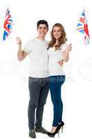 Cheerful couple waving the British flag