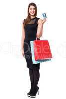 Shopping woman holding up cash card and bags