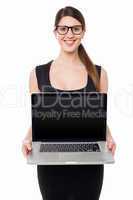 Pretty girl presenting brand new laptop