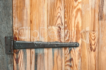 Detail of wooden door with a metal hinge