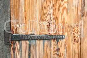 Detail of wooden door with a metal hinge