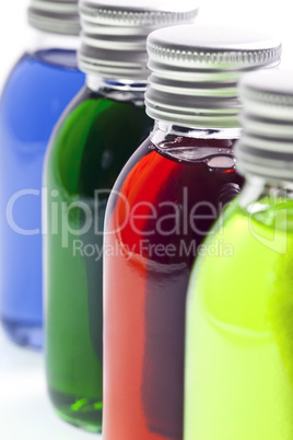 Bottles in a row with different colored liquid