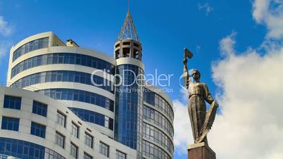 Monument of Eternal Glory to the soldiers. Dnepropetrovsk. Time lapse of running clouds and skyscrapers.