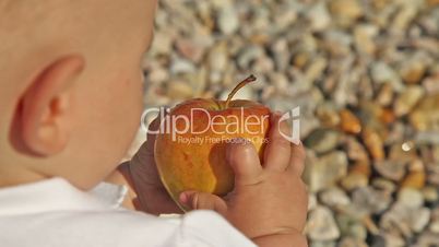 Baby from behind playing with apple