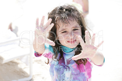 Little girl playing with sand.