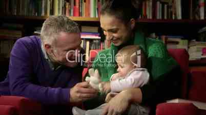 Family portrait, wife and husband playing with baby at home