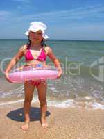 little girl with inflatable circle at the sea