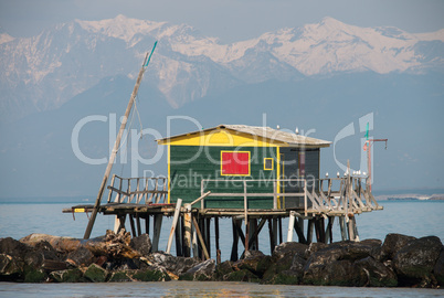 Colorful Palafitte with fishing net over water and rocks, mounta