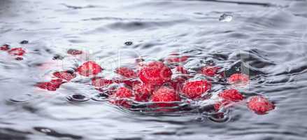 Red Raspberries Dropped into Water with Splash
