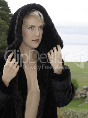 Naked beautiful blond wearing a fur coat