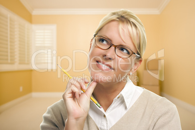 Daydreaming Woman with Pencil in Empty Room and Boxes