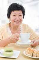 Asian senior woman having breakfast