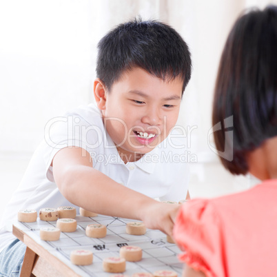 Asian children playing Chinese chess