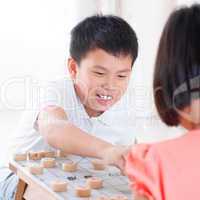 Asian children playing Chinese chess