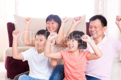 Asian family playing game at home.