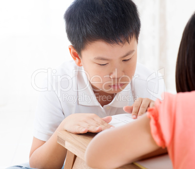 Asian children reading book at home