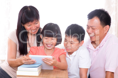 Parents and children using tablet pc together.