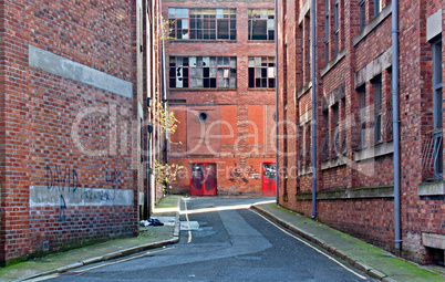 Looking down alleyway towards derelict building