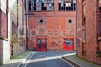 Looking down alleyway towards derelict building