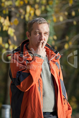 Smoking young man in a park